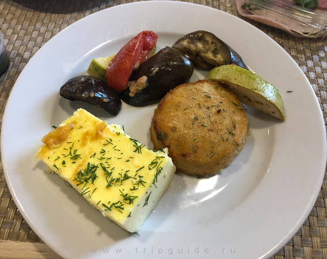 Куриная котлета, омлет, печёные баклажан и кабачки на завтраке в отеле