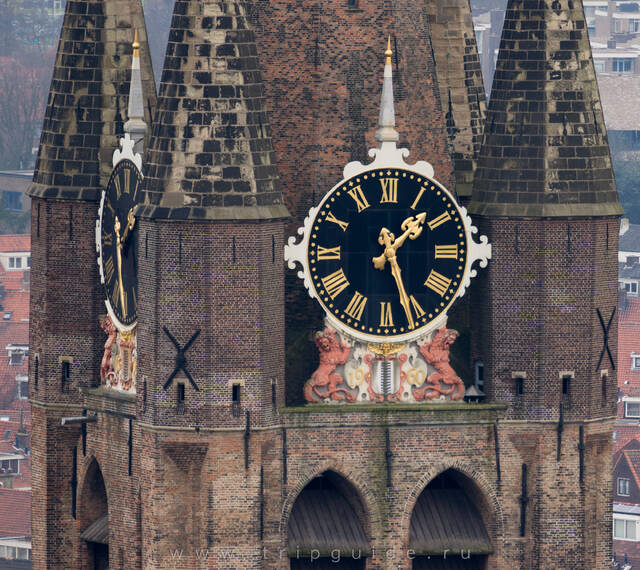 Часы на башне Старой церкви Делфта. Под циферблатом — герб Делфта — серебряный щит с черной полосой с волнистыми границами, которая обозначает канал